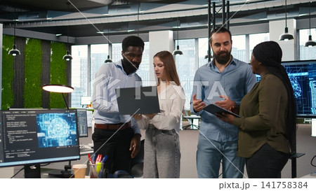 Portrait of teamworking programmers in office developing apps using AI automation. Team of smiling IT experts working on devices, debugging applications with artificial intelligence, camera A Portrait of teamworking programmers in office developing apps using AI automation. Team of smiling IT experts working on devices, debugging applications with artificial intelligence, camera A 141758384