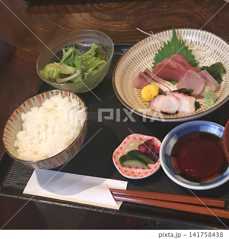 刺身定食とご飯、サラダが並ぶ和食のランチ 141758438