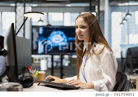 Cheerful junior dev in office using AI on computer to streamline app development. Joyous IT department intern at desk using PC to run debugging programs with machine learning technology Cheerful junior dev in office using AI on computer to streamline app development. Joyous IT department intern at desk using PC to run debugging programs with machine learning technology 141759051