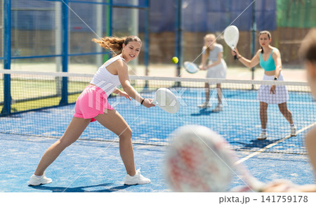 Woman playing with other paddle tennis players Woman playing with other paddle tennis players 141759178