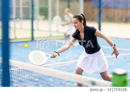 Adult woman playing doubles padel tennis 141759188