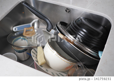 Dirty dishes are piled in a kitchen sink 141759231