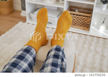 Person wearing yellow socks in a cozy indoor setting 141759250