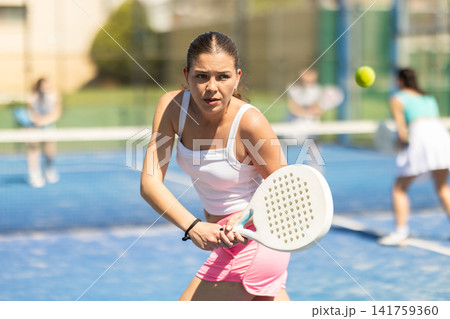 Woman on the court playing paddle tennis Woman on the court playing paddle tennis 141759360