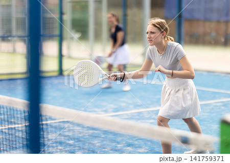 Young woman playing doubles padel tennis 141759371