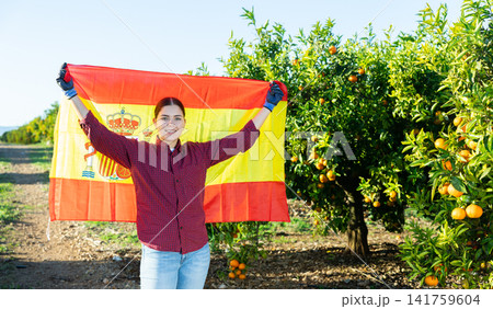Girl football fan waving Spanish flag during tangerines harvest 141759604
