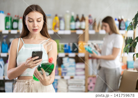 Woman scans dish detergent on her phone Woman scans dish detergent on her phone 141759678
