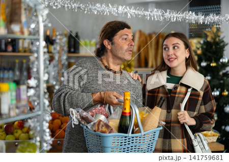 Husband and wife buy groceries at the supermarket for upcoming Christmas celebration 141759681