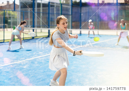 Athletic woman playing racket in paddle tennis weekend in parks 141759778