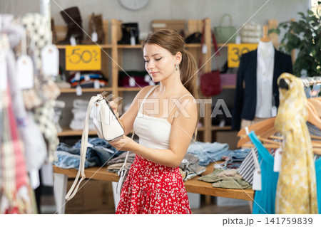 In trading hall, girl choose and buy ladys handbag In trading hall, girl choose and buy ladys handbag 141759839