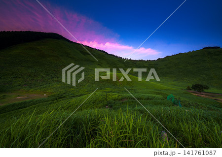 奈良県曽爾村の曽爾高原の丘から二本ボソと亀山峠夕景 12mm超広角レンズ 亀山峠稜線で輝く茜雲 141761087