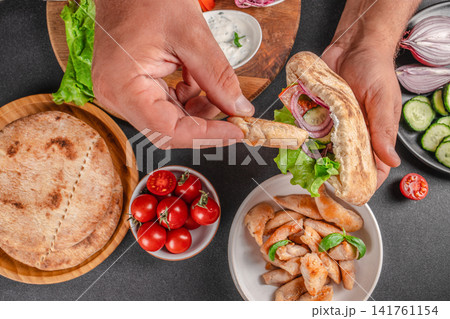 Chef Filling Pita Pocket with Chicken and Vegetables Chef Filling Pita Pocket with Chicken and Vegetables 141761154