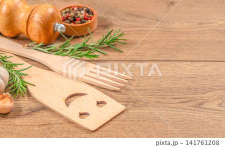 Rustic kitchen utensils with rosemary, garlic and spices on wooden table background with copy space Rustic kitchen utensils with rosemary, garlic and spices on wooden table background with copy space 141761208