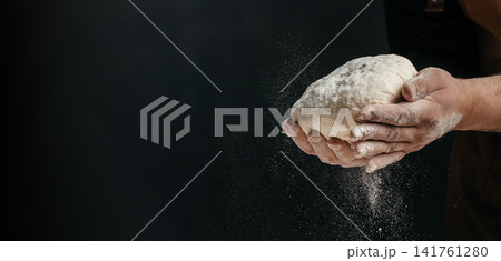 Baker holding artisan dough with flour dust and copy space Baker holding artisan dough with flour dust and copy space 141761280
