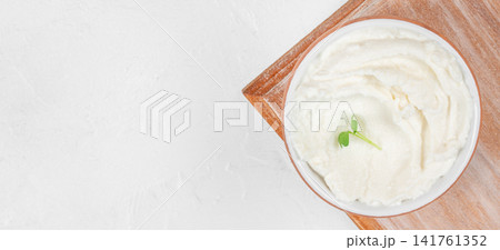 Fresh cream cheese in rustic bowl with microgreens and copy space 141761352