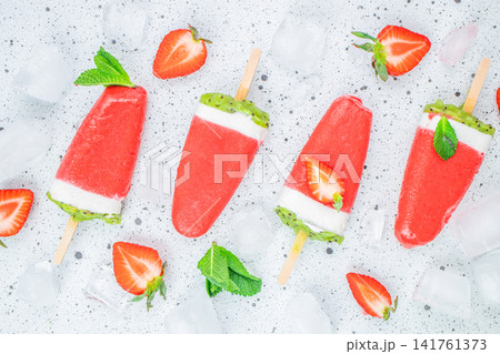 Strawberry kiwi yogurt popsicles with ice cubes on light background Strawberry kiwi yogurt popsicles with ice cubes on light background 141761373
