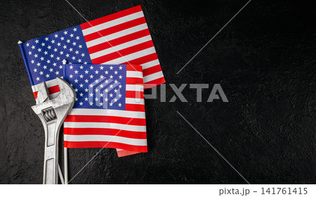 Adjustable wrench and American flags on black background, Labor Day and skilled worker concept Adjustable wrench and American flags on black background, Labor Day and skilled worker concept 141761415