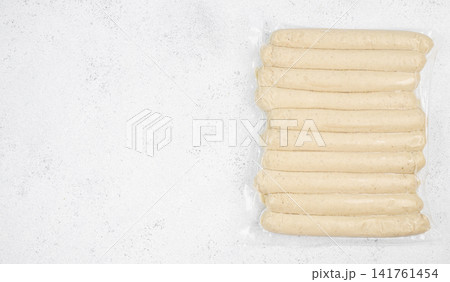 Vacuum packed white sausages on light textured background with copy space 141761454