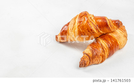 Two Fresh Butter Croissants on Light Background with Copy Space 141761503