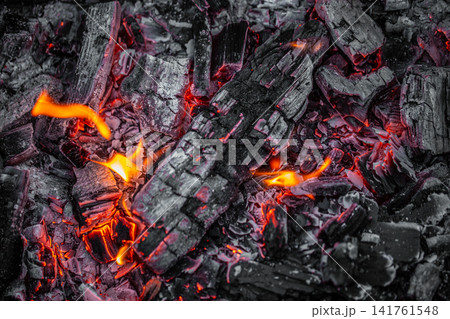Glowing charcoal embers with flames background close up 141761548