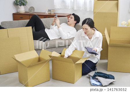 引っ越し作業中に怠ける男性と文句を言う女性 引っ越し作業中に怠ける男性と文句を言う女性 141763032