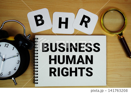 BHR Business Human Rights text written on notepad with magnifying glass and alarm clock on wooden background BHR Business Human Rights text written on notepad with magnifying glass and alarm clock on wooden background 141763208