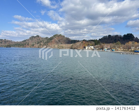 青森県十和田市の湖、十和田湖のフェリーターミナルを出発した遊覧船から見た湖と陸地です。 青森県十和田市の湖、十和田湖のフェリーターミナルを出発した遊覧船から見た湖と陸地です。 141763412