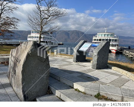 青森県十和田市の湖、十和田湖の遊覧船フェリーターミナルの案内図と停泊する二隻の遊覧船です。 青森県十和田市の湖、十和田湖の遊覧船フェリーターミナルの案内図と停泊する二隻の遊覧船です。 141763655
