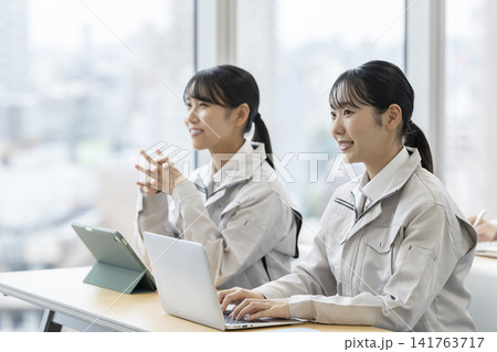研修を受ける作業服を着た若い女性 研修を受ける作業服を着た若い女性 141763717