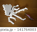 床に置かれた餌木を抱こうとするイカ 141764003