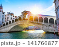 Historic Rialto Bridge illuminated by sunlight over the Grand Canal in Venice, Italy. One of the most photographed architectural landmarks in Europe. 141766877