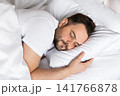 Close-up portrait of a relaxed man sleeping soundly on a soft pillow. Ideal concept for healthy lifestyle, sleep quality, stress relief and personal wellbeing. 141766878