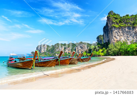 Traditional Thai longtail boats anchored on the white sand of Railay Beach near Ao Nang, Krabi in Thailand. Traditional Thai longtail boats anchored on the white sand of Railay Beach near Ao Nang, Krabi in Thailand. 141766883