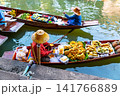 Traditional vendors selling fresh tropical fruit from wooden boats at the famous Damnoen Saduak Floating Market near Bangkok in Thailand. 141766889