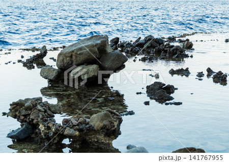 Natural pools with calm blue water along the Red Sea coast in Dahab, Egypt. Rocky shoreline under the Sinai mountains with clear blue water. Natural pools with calm blue water along the Red Sea coast in Dahab, Egypt. Rocky shoreline under the Sinai mountains with clear blue water. 141767955