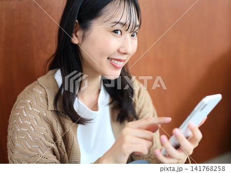 笑顔でスマホを操作する`女性イメージ 笑顔でスマホを操作する`女性イメージ 141768258