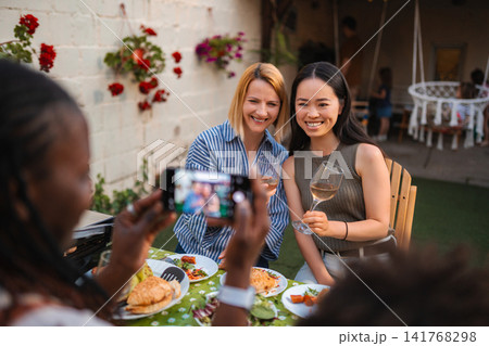 Diverse adult women enjoying outdoor party while taking picture Diverse adult women enjoying outdoor party while taking picture 141768298