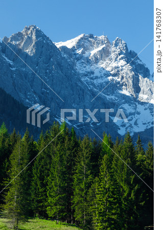 Travel landscape of Zugspitze Alps in Bavaria, Germany, scenic summer nature panorama with forest, snow mountains peak. Alpine landscape 141768307
