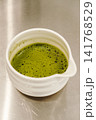 Close-up of freshly prepared matcha tea with smooth foam in a ceramic bowl. Traditional Japanese green tea ready to serve 141768529