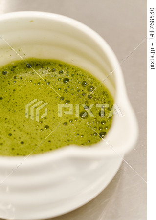 Close-up of freshly prepared matcha tea with smooth foam in a ceramic bowl. Traditional Japanese green tea ready to serve Close-up of freshly prepared matcha tea with smooth foam in a ceramic bowl. Traditional Japanese green tea ready to serve 141768530