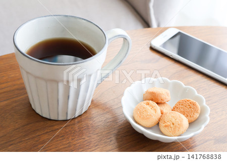 木製テーブルの上のホットコーヒーとクッキーとスマートフォン/コーヒータイム 木製テーブルの上のホットコーヒーとクッキーとスマートフォン/コーヒータイム 141768838