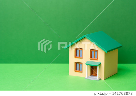 A green house on a green background. Eco-friendly house. Autonomy and independence of housing. Innovative technologies, household self-sufficiency. High energy efficiency. A green house on a green background. Eco-friendly house. Autonomy and independence of housing. Innovative technologies, household self-sufficiency. High energy efficiency. 141768878