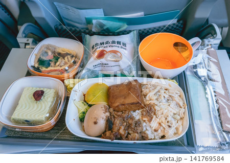 旅客機の座席で提供されたアジア料理の機内食 旅客機の座席で提供されたアジア料理の機内食 141769584