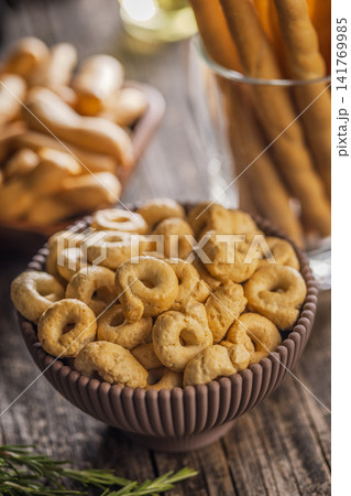 Rustic Italian Taralli Snack Bowl With Breadsticks Olive Oil and Fresh Rosemary on Wooden Table Rustic Italian Taralli Snack Bowl With Breadsticks Olive Oil and Fresh Rosemary on Wooden Table 141769985