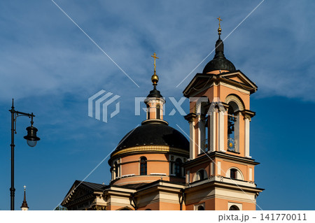 Sunlit Pink Orthodox Church With Dome And Bell Tower Against Blue Sky Sunlit Pink Orthodox Church With Dome And Bell Tower Against Blue Sky 141770011