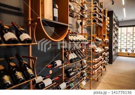 Modern wine shop interior displaying various red wine bottles Modern wine shop interior displaying various red wine bottles 141770136