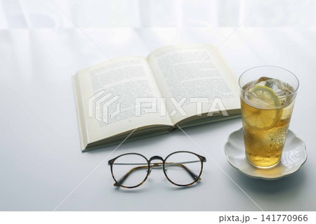 レモン入りアイスティーと本とメガネのあるくつろぎの読書時間 レモン入りアイスティーと本とメガネのあるくつろぎの読書時間 141770966
