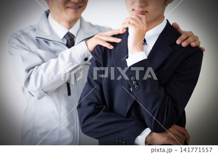 悩むリクルートスーツを着た若い男性と若手に期待する作業服のミドル男性 141771557