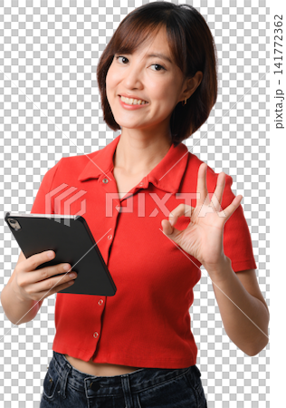 Asian woman holding tablet in red shirt smiling and making okay gesture, isolated portrait for communication, technology and business concept Asian woman holding tablet in red shirt smiling and making okay gesture, isolated portrait for communication, technology and business concept 141772362