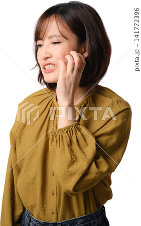 Asian woman smiling portrait isolated in mustard blouse touching cheek with gentle expression and relaxed pose against transparent background Asian woman smiling portrait isolated in mustard blouse touching cheek with gentle expression and relaxed pose against transparent background 141772396